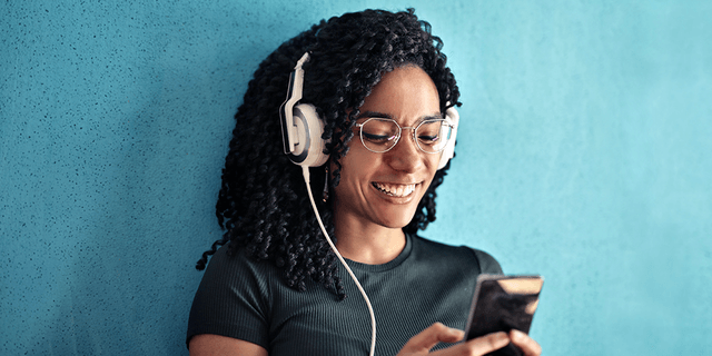 Woman with headphones on looking at her phone