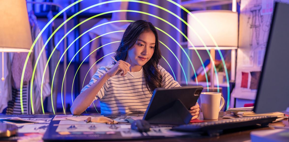 Women on laptop with pen in hand, surrounded by circles.